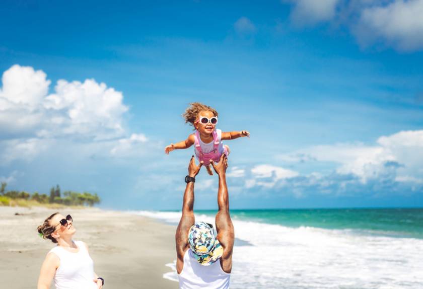 parents palying with child on emerald coast beach